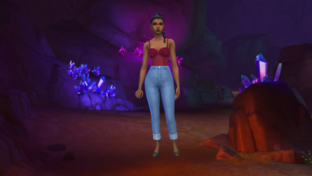 Un sim con jeans de talle alto azules y un body corsé rojo con el pelo trenzado. Detrás de este sim hay una imagen del mundo de Los Sims 4 de la Gruta Olvidada como fondo de pantalla de CAS.
