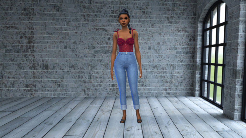 Un sim con jeans azules de cintura alta y un body corsé rojo con el cabello recogido en una trenza. El fondo de pantalla CAS de Los Sims 4 para este sim es un suelo de madera gris con una pared de ladrillos grises detrás de ellos.