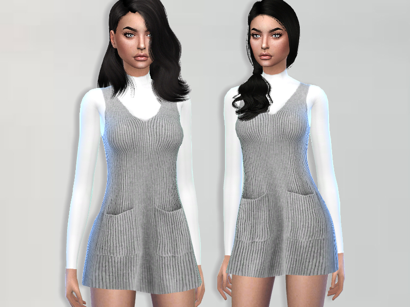 La misma sim llevando una camiseta blanca de manga larga debajo de un vestido gris con cordones que tiene bolsillos y un escote en forma de cucharada.