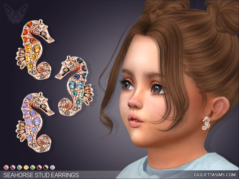 Un niño pequeño de Los Sims 4 con cabello castaño en moños espaciales y ojos castaños. Lleva puestos unos pendientes de estudio de oro rosa que parecen un caballito de mar y tienen pequeñas gemas de diferentes colores en su interior.