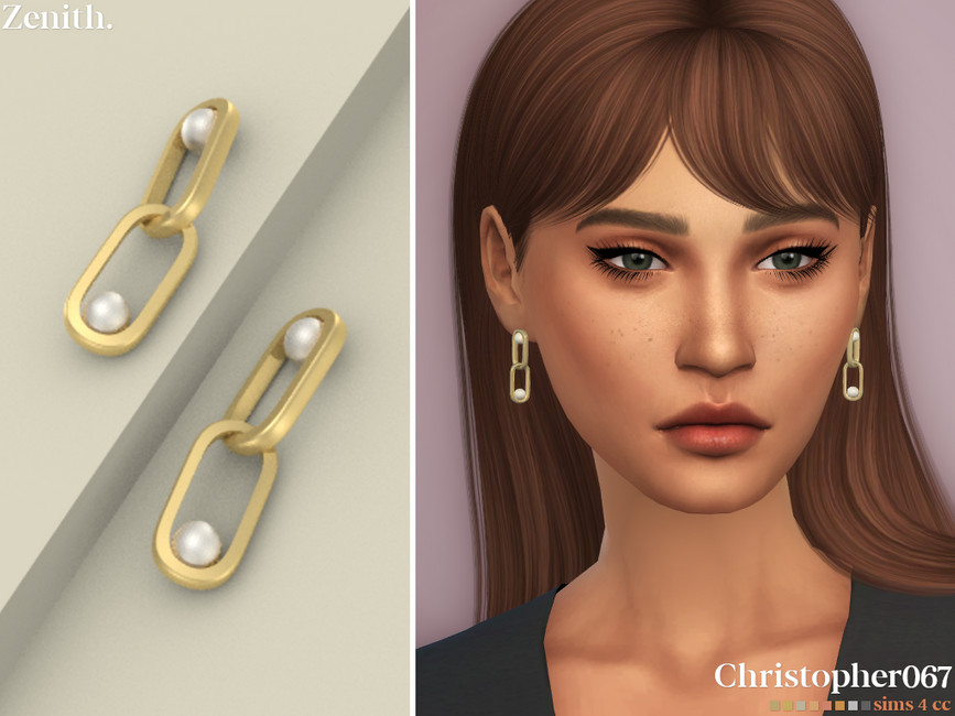 Un sim con cabello castaño, ojos verdes y pecas. Llevan puestos pendientes dorados con dos eslabones de cadena con perlas en su interior.